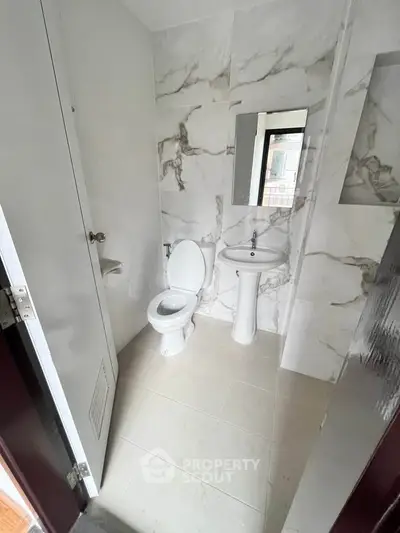 Modern bathroom with marble tiles and compact design