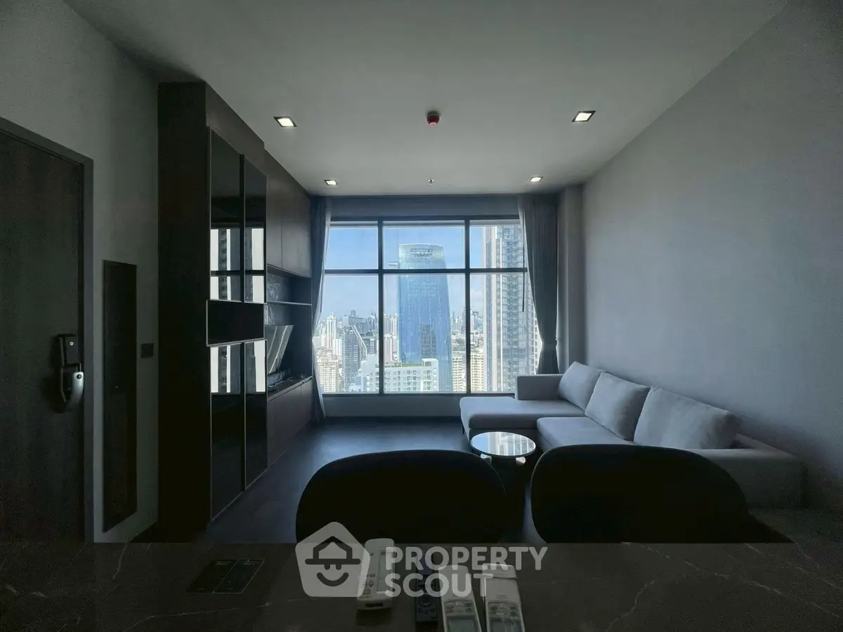 Modern living room with stunning city view and sleek furniture in high-rise apartment.