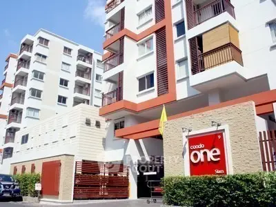 Modern condominium building exterior with stylish design and vibrant colors in urban setting.