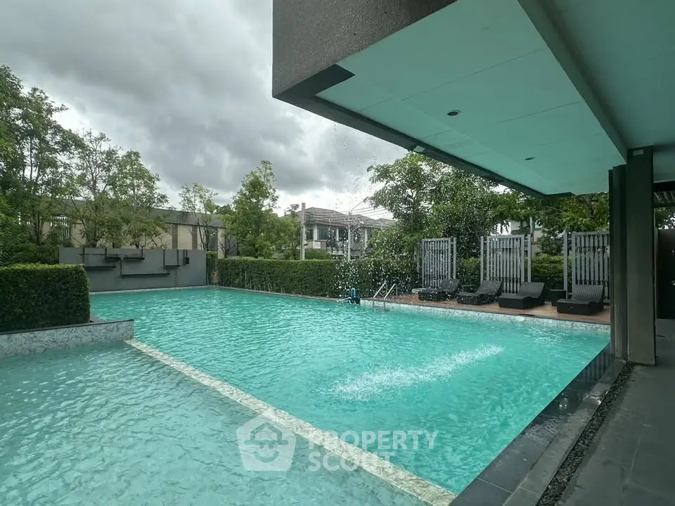 Luxurious outdoor pool area with modern design and lush greenery, perfect for relaxation and leisure.