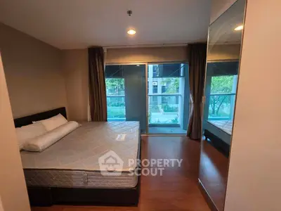 Spacious bedroom with large window and garden view, featuring a comfortable bed and elegant decor.