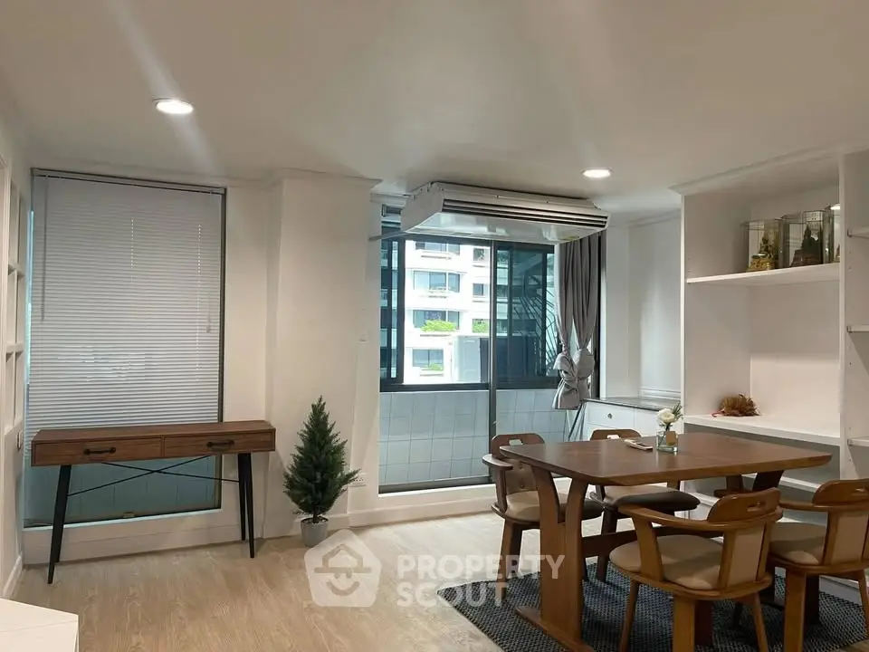 Spacious dining area with modern furniture and natural light in a stylish apartment.