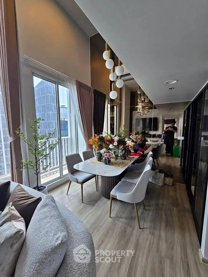 Luxurious modern living room with elegant dining area and large windows offering city views.