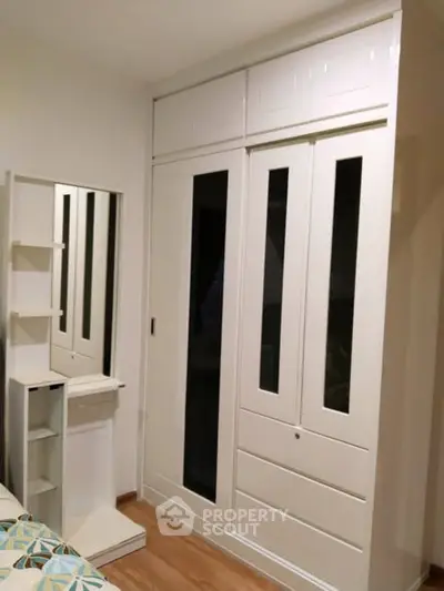 Modern bedroom with sleek white wardrobe and vanity unit