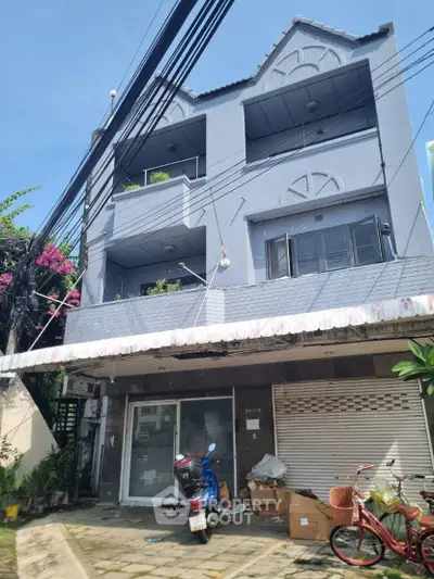 Charming three-story building with balconies and street view, ideal for urban living.