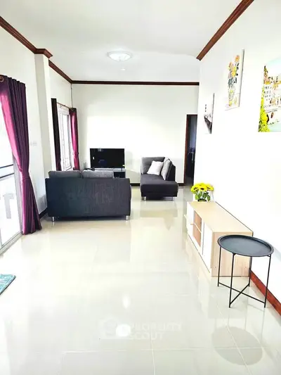 Spacious living room with modern decor and natural light, featuring sleek furniture and vibrant accents.