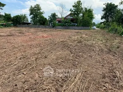 Expansive plot of land with potential for development, surrounded by lush greenery and a serene environment.