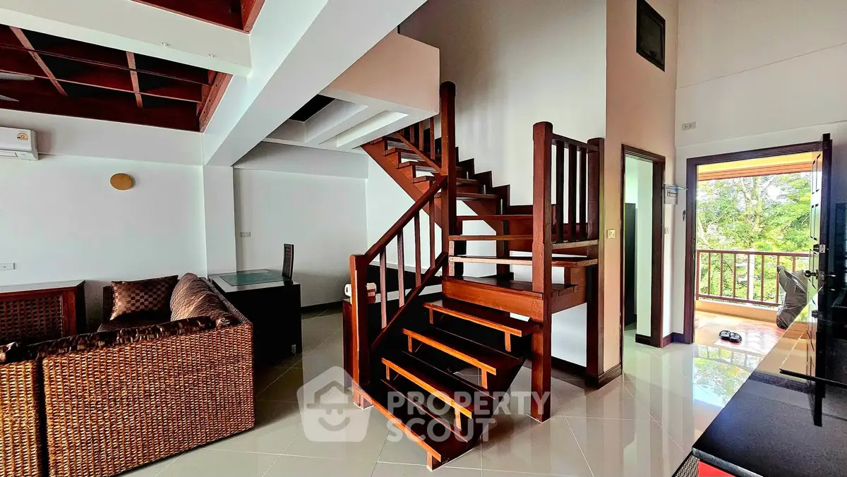 Stunning duplex interior with wooden staircase and cozy living area