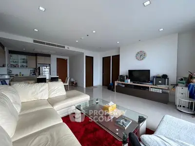 Spacious modern living room with sleek furniture and open kitchen layout, perfect for family gatherings.