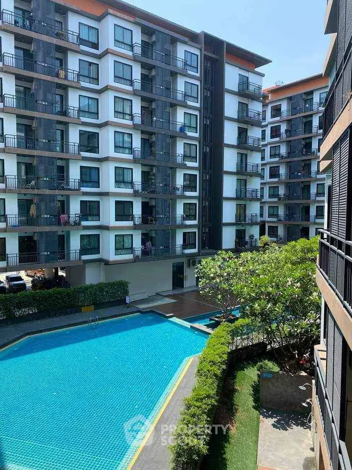 Modern apartment complex with pool and lush greenery, perfect for urban living.