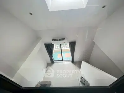 Modern minimalist interior with high ceiling and large window view