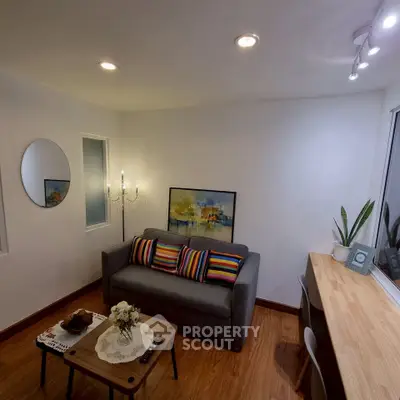 Cozy living room with modern decor, featuring a stylish sofa, vibrant cushions, and elegant lighting.