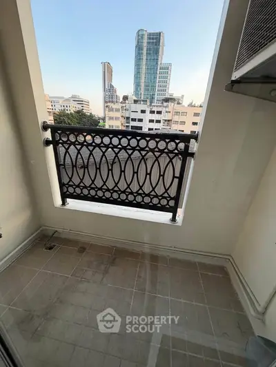 Charming urban balcony with cityscape view, perfect for relaxation and enjoying the skyline.