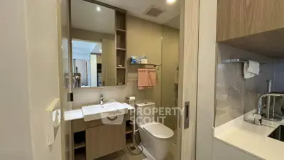 Modern bathroom with sleek fixtures and wooden cabinetry in a contemporary apartment.