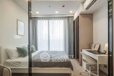 Modern bedroom with stylish decor, large window, and cozy workspace, perfect for urban living.