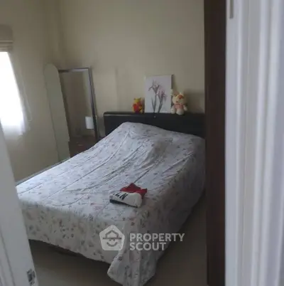 Cozy bedroom with floral bedding and plush toys, perfect for relaxation.