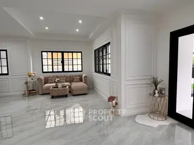 Luxurious living room with elegant decor and large windows, featuring marble flooring and plush seating.