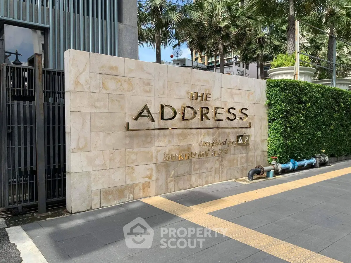Elegant entrance of The Address Sukhumvit 28 with lush greenery and modern design.