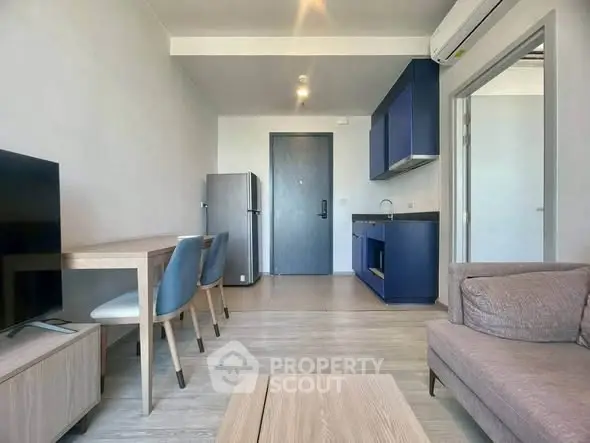 Modern living room with sleek furniture and open kitchen layout in a stylish apartment.