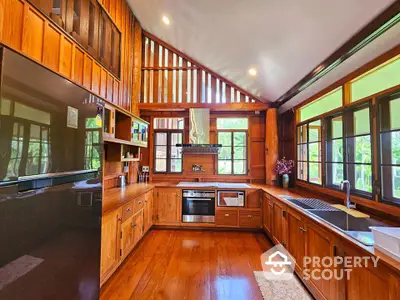 Stunning wooden kitchen with modern appliances and large windows for natural light