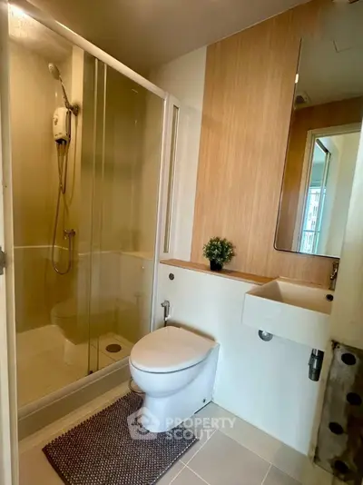 Modern bathroom with shower enclosure and sleek fixtures in a contemporary apartment.