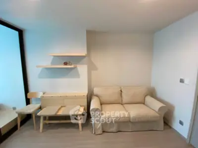 Cozy living room with beige sofa and minimalist wooden furniture, perfect for modern living.