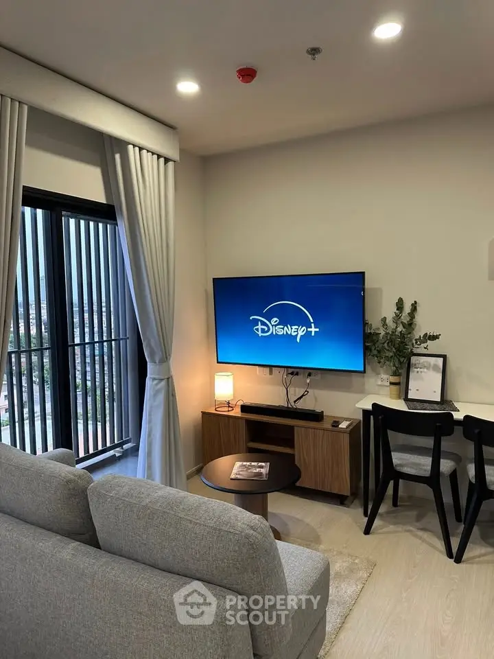 Modern living room with cozy sofa, wall-mounted TV, and stylish decor, perfect for relaxation and entertainment.