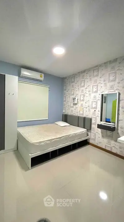 Modern bedroom with stylish decor and ample storage in a cozy apartment.