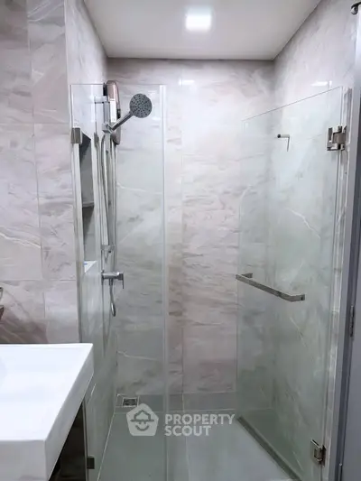 Modern bathroom with glass shower enclosure and sleek fixtures
