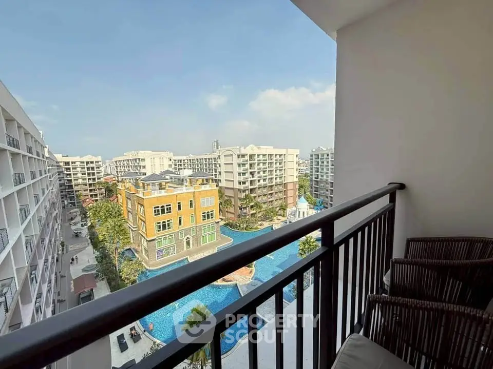 Stunning balcony view overlooking modern apartment complex with pool and lush surroundings.