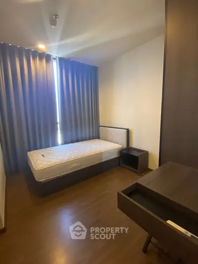 Cozy bedroom with single bed and modern furnishings, ideal for minimalist living.
