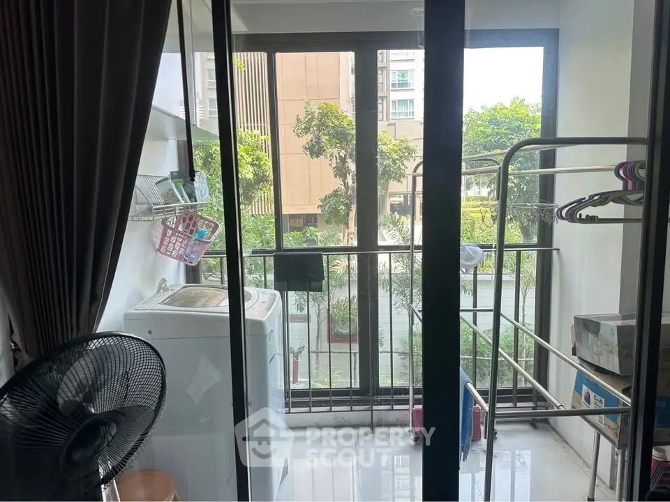 Compact balcony with washing machine and drying racks in urban apartment