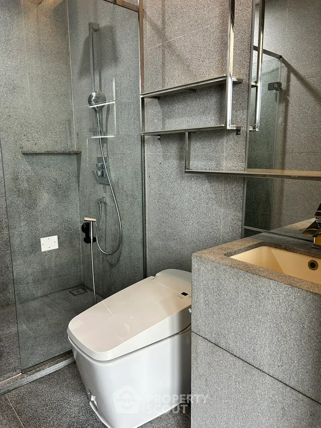 Modern bathroom with sleek gray tiles and glass shower enclosure