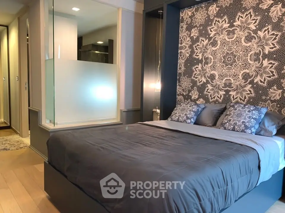 Luxurious bedroom with elegant decor and stylish wallpaper, featuring a cozy bed and modern lighting.
