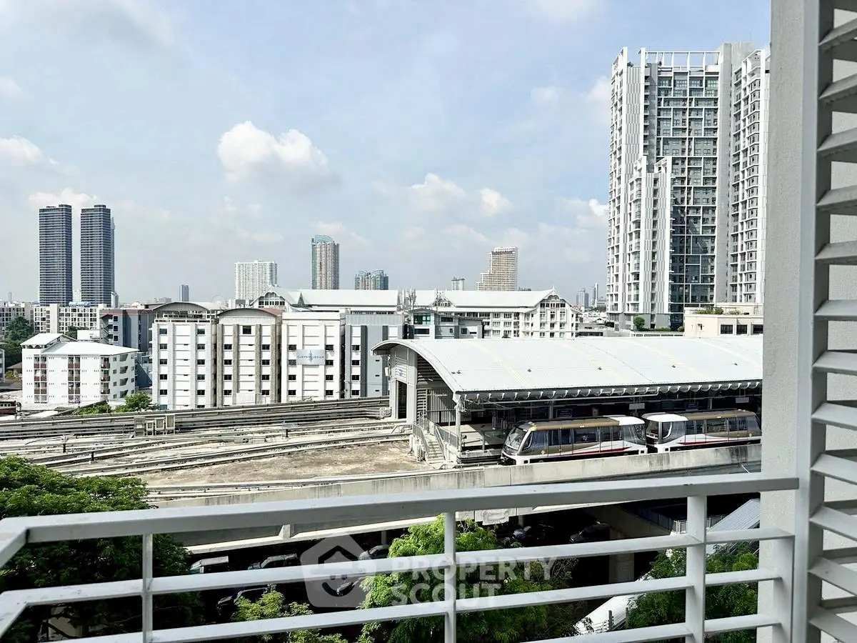 Stunning urban view from balcony overlooking city skyline and train station.