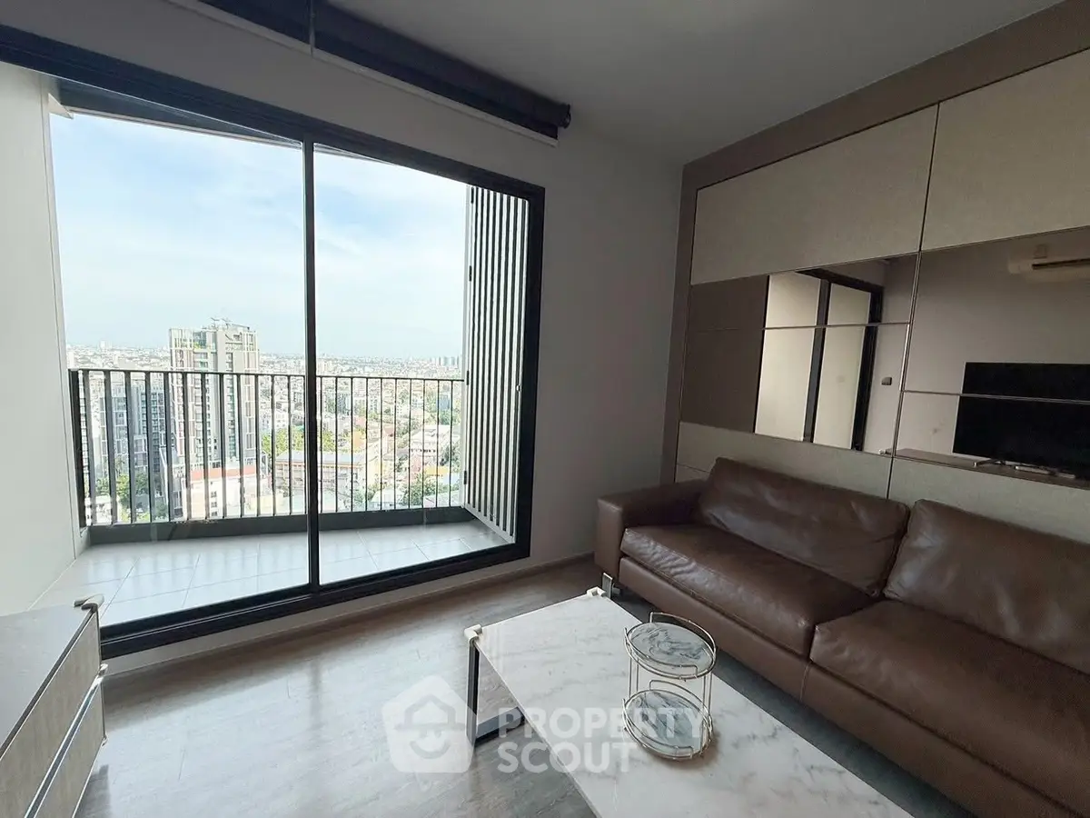 Modern living room with leather sofa and stunning city view from balcony.