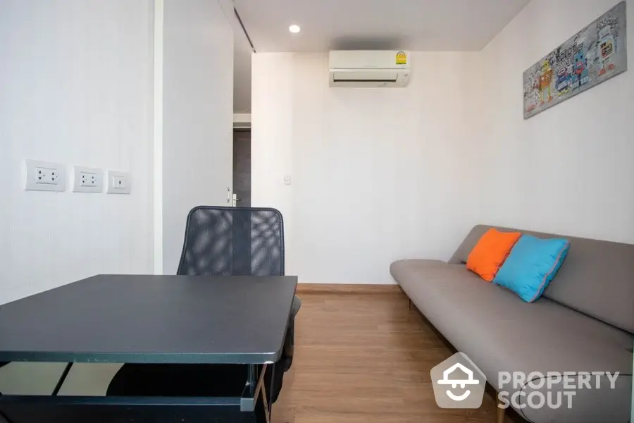 Modern small living room with sofa, desk, and air conditioning