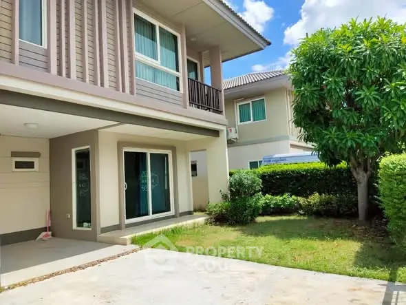 Charming two-story house with lush garden and modern exterior design.