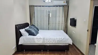 Cozy bedroom with modern decor and large window for natural light