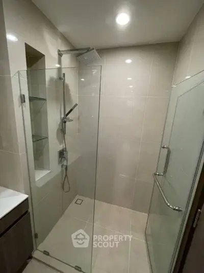 Modern bathroom with glass shower enclosure and sleek fixtures