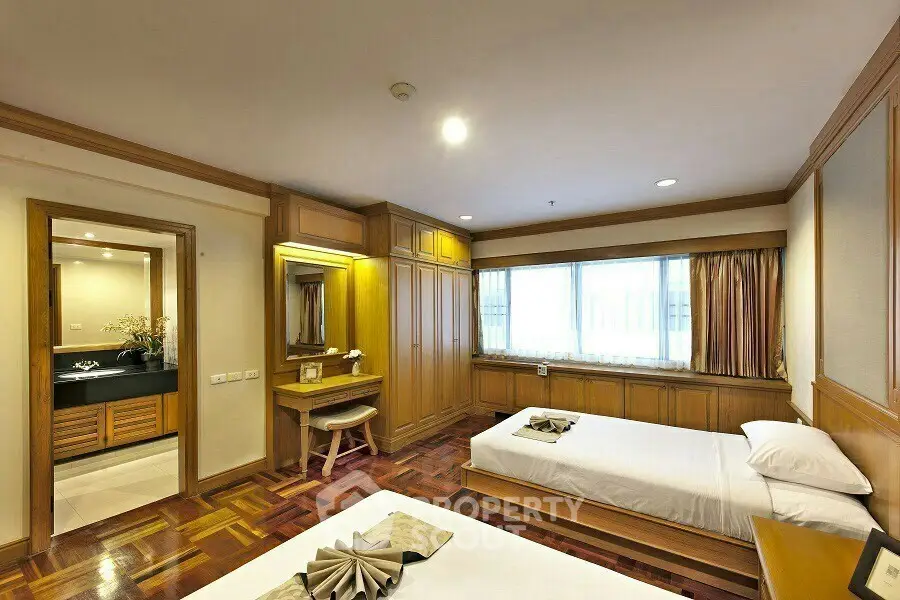 Spacious bedroom with elegant wooden furnishings and ample natural light.