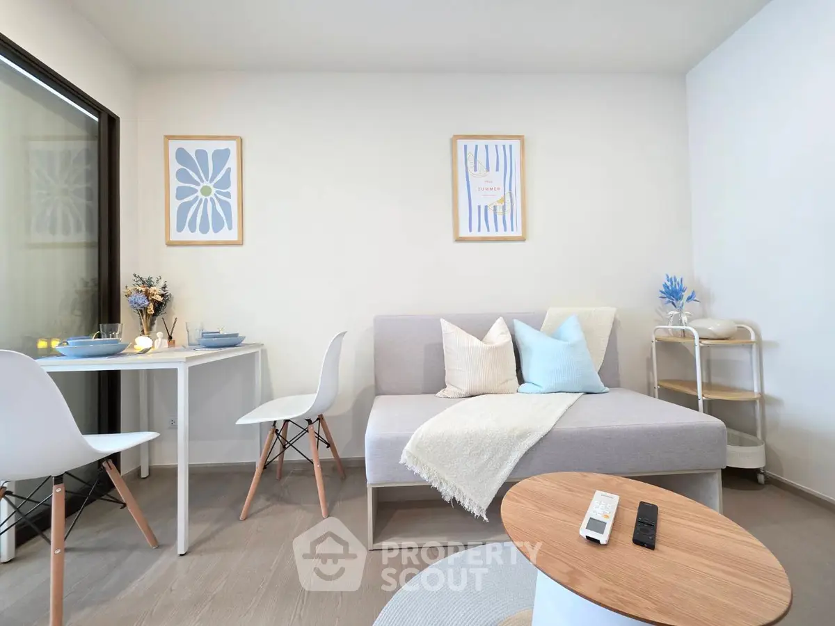 Modern living room with stylish decor and natural light, featuring a cozy sofa and dining area.