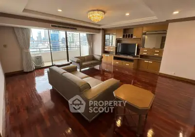 Spacious living room with elegant hardwood floors and city view balcony in luxury apartment.