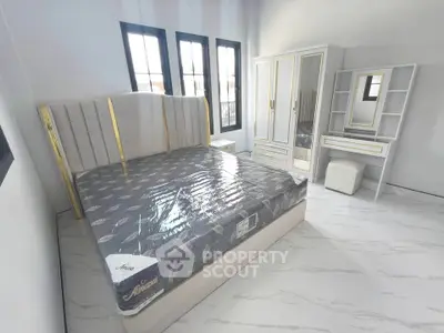 Spacious bedroom with elegant bed, wardrobe, and vanity set in modern design.
