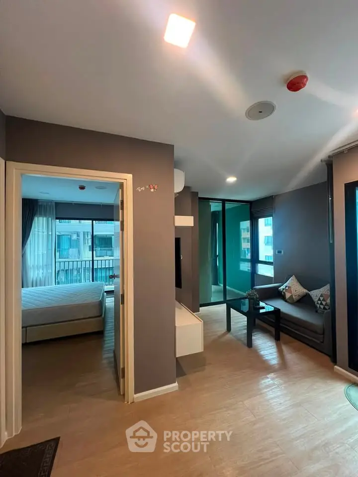 Modern apartment interior with cozy living room and bedroom view, featuring stylish decor and natural light.