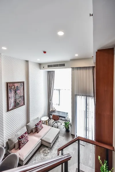 Elegant living room with high ceiling and modern decor in a stylish apartment.