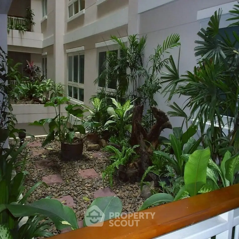 Lush indoor garden in modern building atrium with vibrant greenery and natural light.
