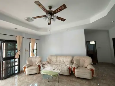 Spacious living room with elegant ceiling fan and comfortable seating