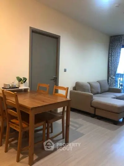 Cozy living room with wooden dining set and comfortable sofa in modern apartment.