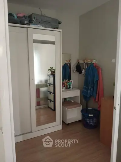 Cozy bedroom with mirrored wardrobe and organized storage space.